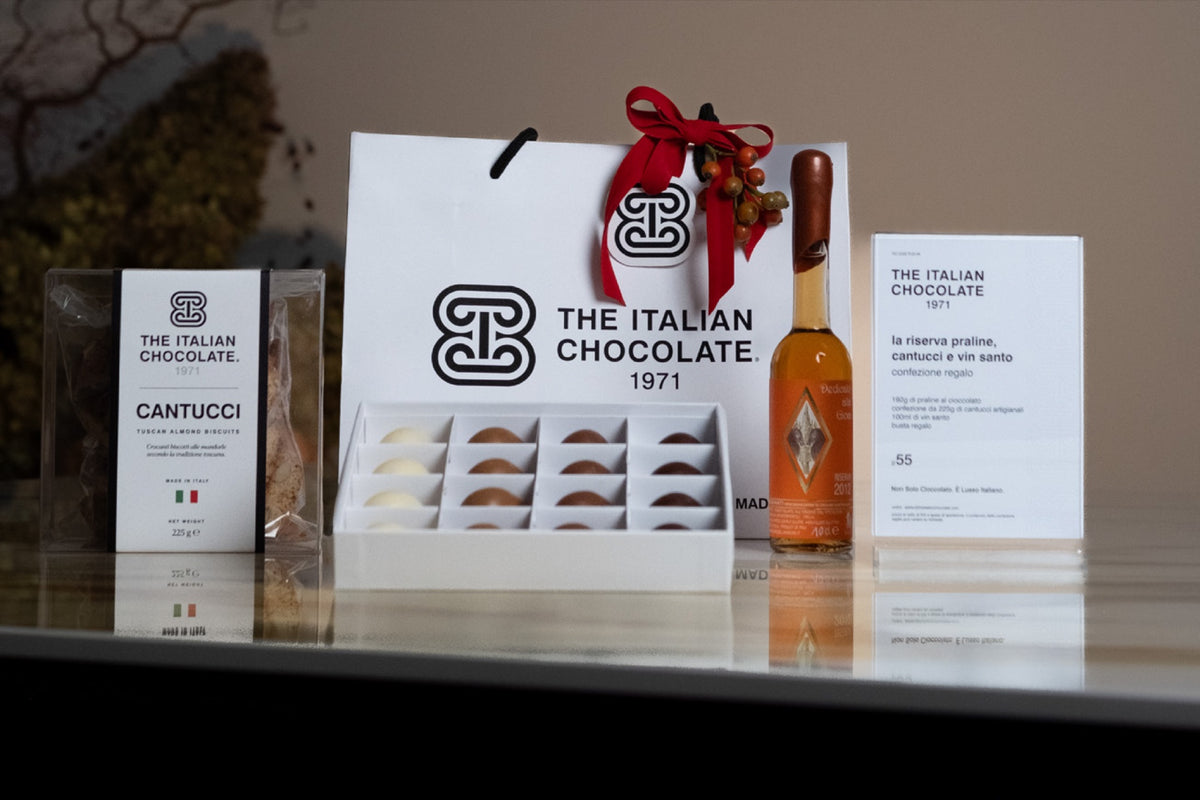La Riserva gift set: gift bag with red ribbon, an open box of 16 pralines, a box of cantucci and a 100 ml bottle of Vin Santo