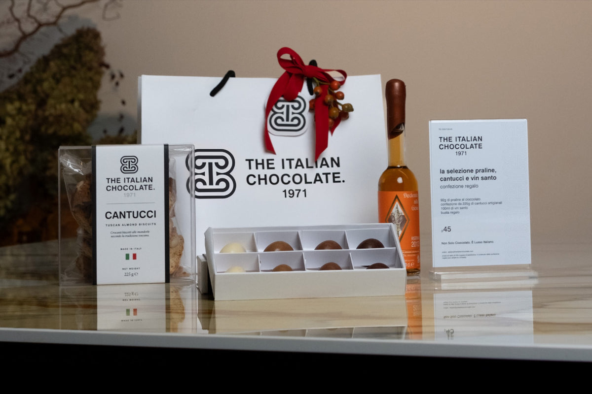 La Selezione gift set: gift bag with red ribbon, an open box of 8 pralines, a box of cantucci and a 100 ml bottle of Vin Santo